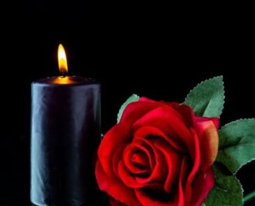 front-view-dark-candle-with-red-rose-dark-surface